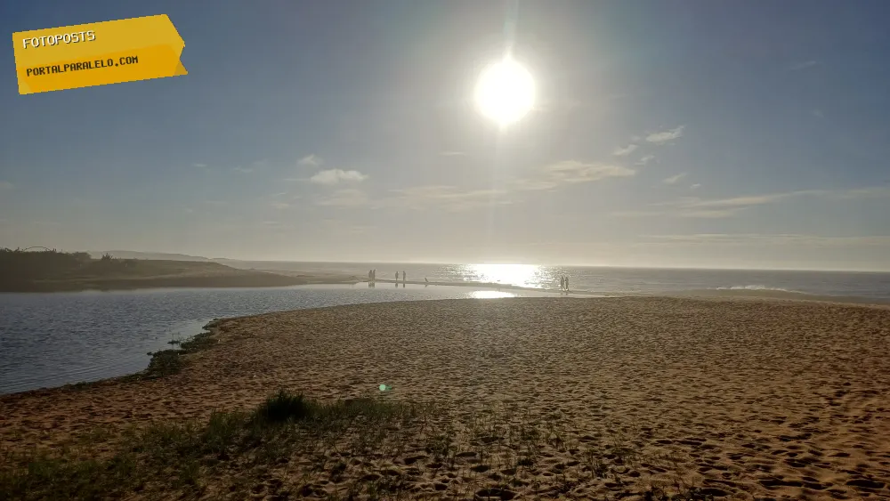 Lagoa desaguando na praia ao amanhecer